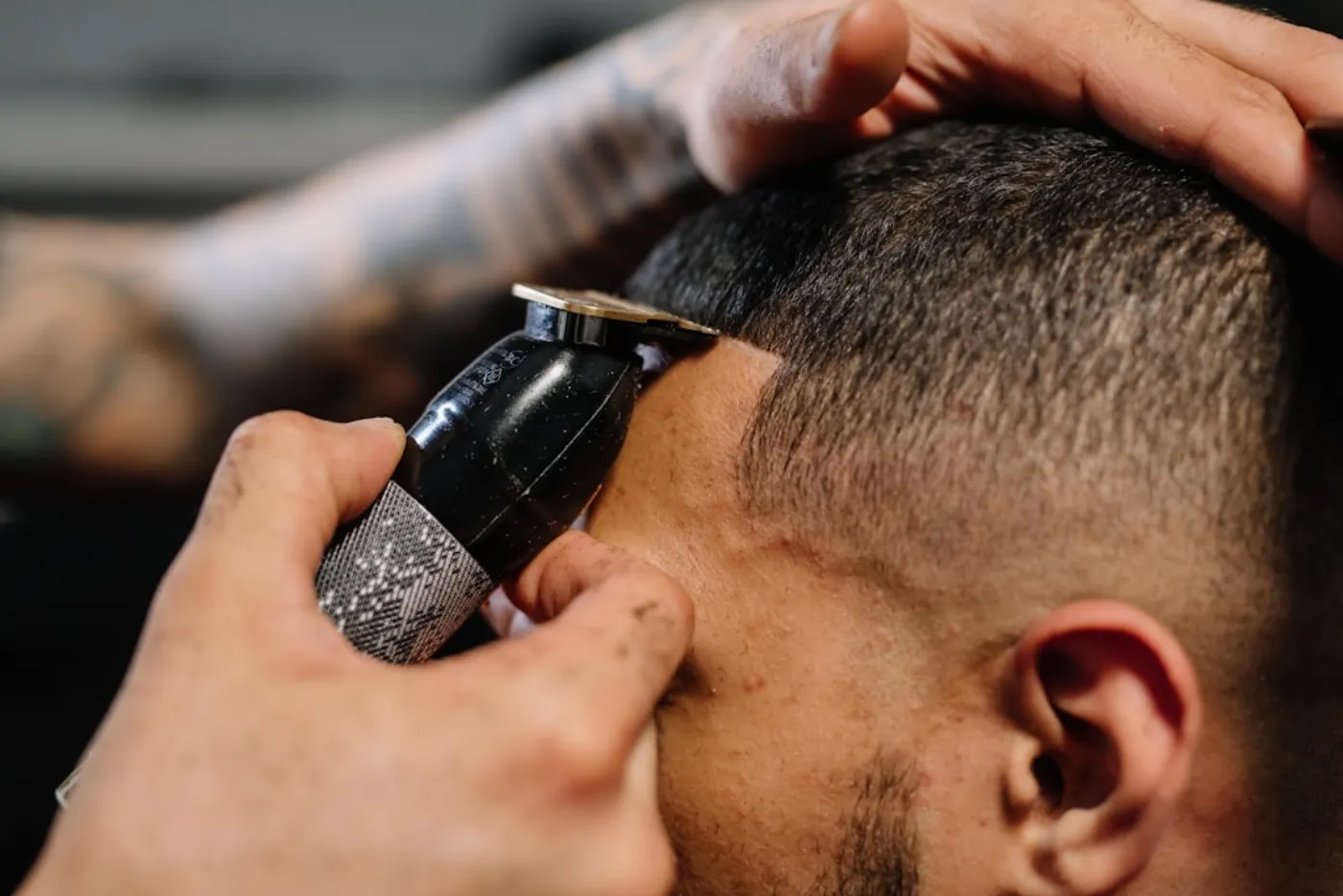 Professional barber sculpting a sharp beard line on a client