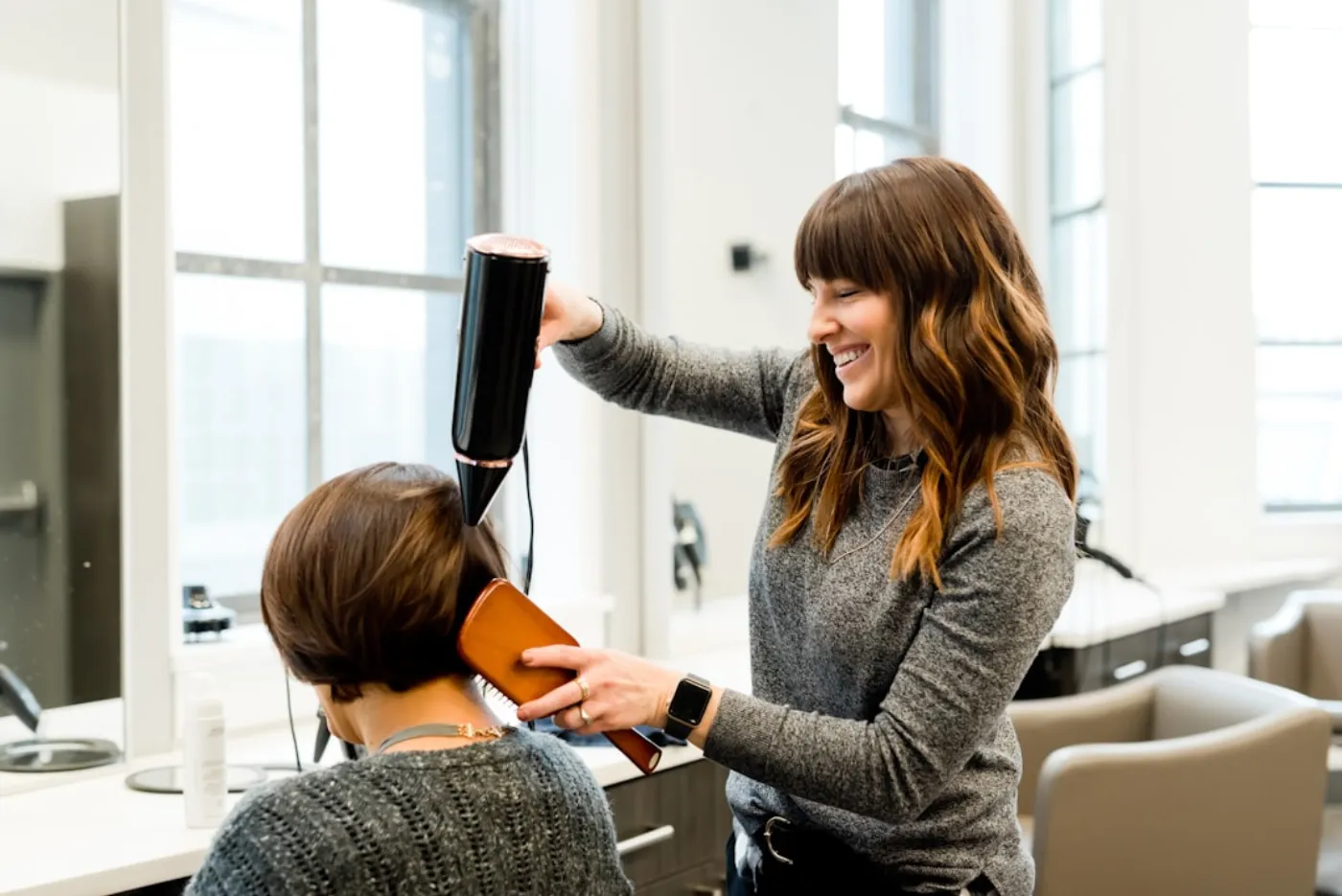 Barber carefully styling a man's hair at a salon