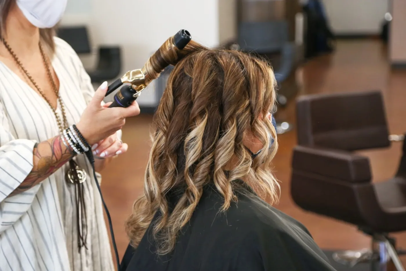 Master colourist applying precision toner at salon station