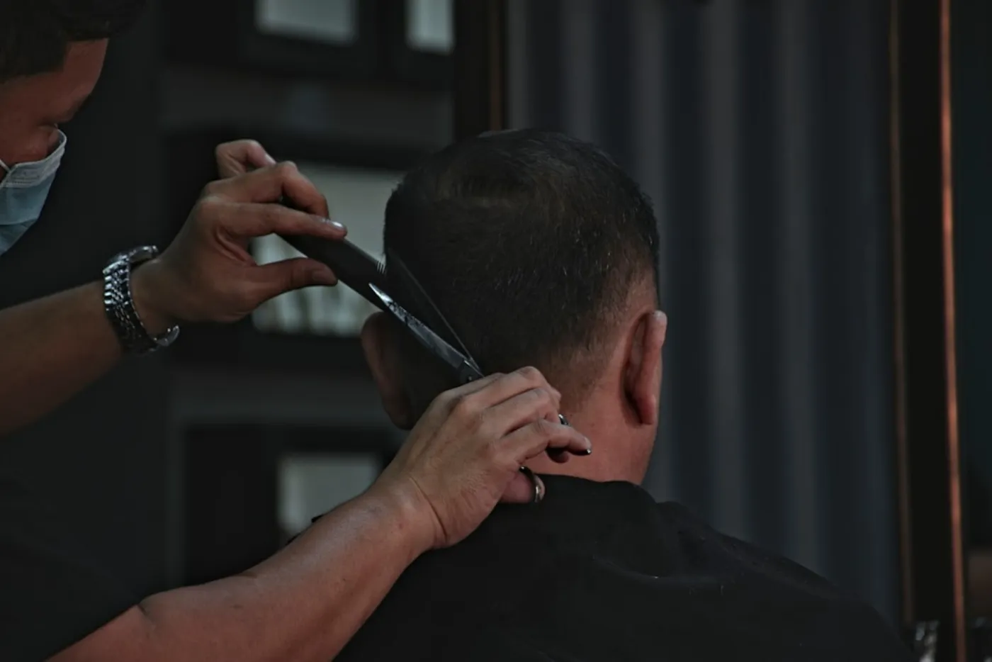 Male client receiving precision hair styling at salon