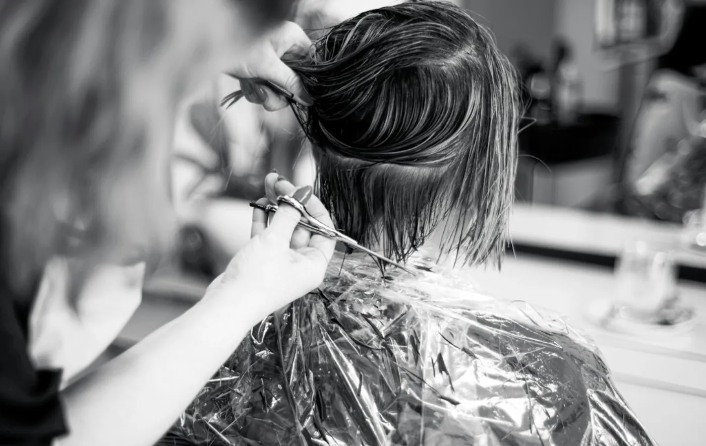A client receiving subtle grey blending highlights in a salon chair