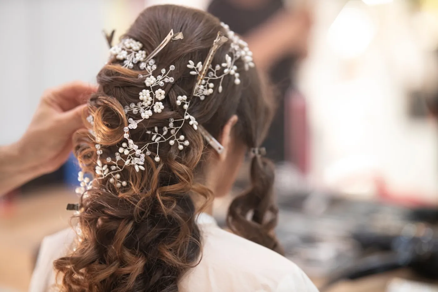 Hairstylist working on a bride's elegant updo in a salon