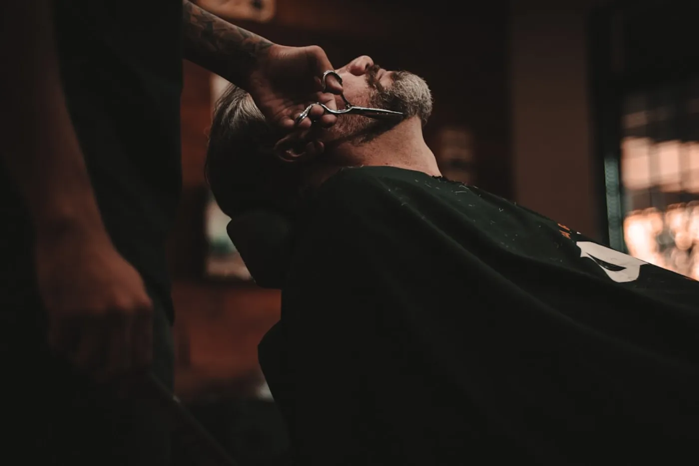 A man receiving a precise beard trim and grooming from a skilled barber at House of Salons, showcasing expert men's grooming.