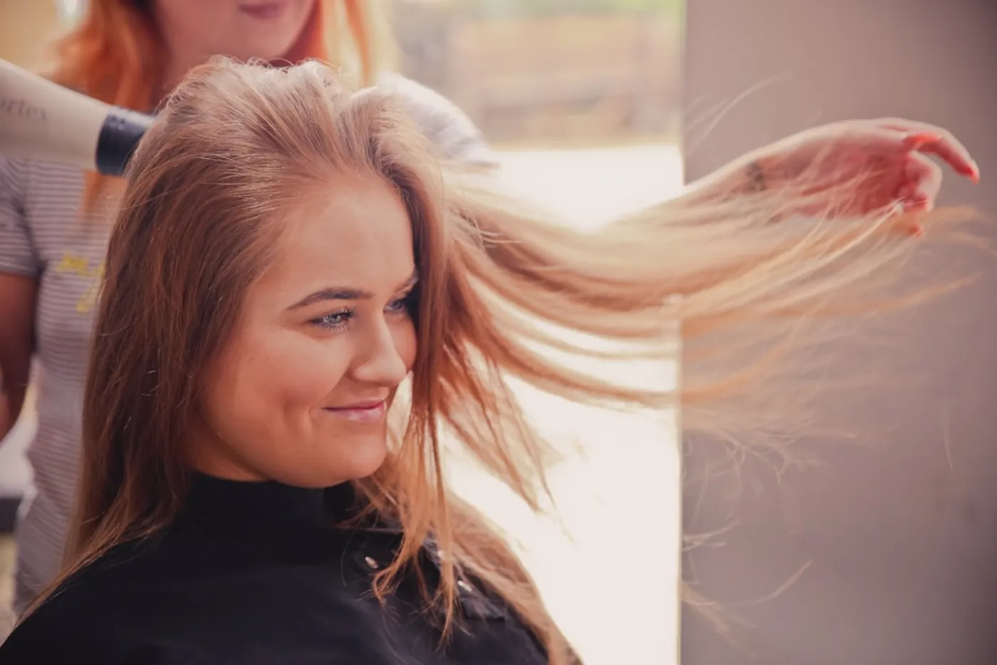 Hair stylist applying a protective treatment to client's hair