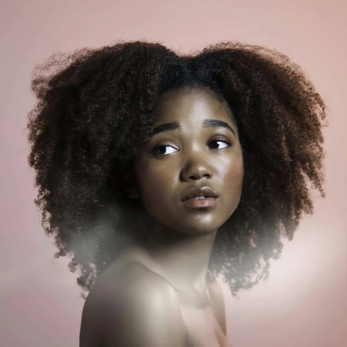 A woman with healthy, textured curls — keratin smooths frizz without erasing natural movement