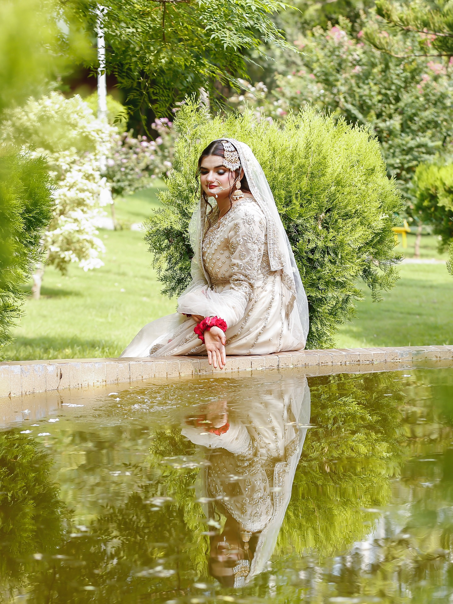Bridal hair and makeup portrait beside a reflecting pool by House of Salons