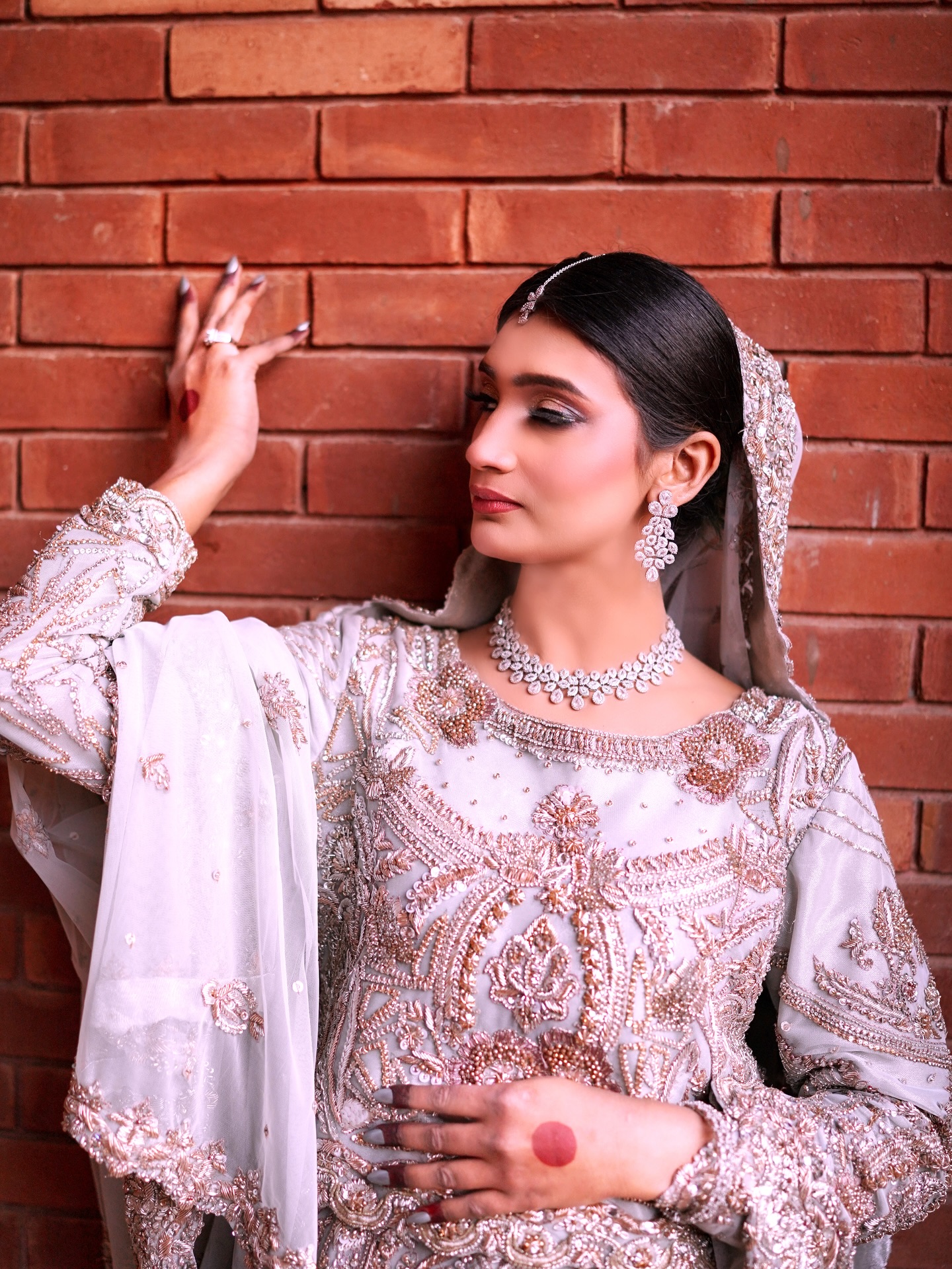 Bridal glam makeup portrait against a brick wall by House of Salons
