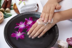 hands-against-white-surface-spa-treatment-product-female-hand-spa-massage-perfumed-flowers-water-candles-relaxation-flat-lay-top-view.