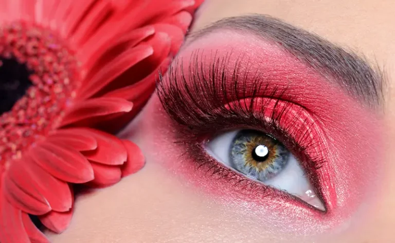 fashion-woman-eye-with-red-make-up-long-false-eyelashes-flower-background