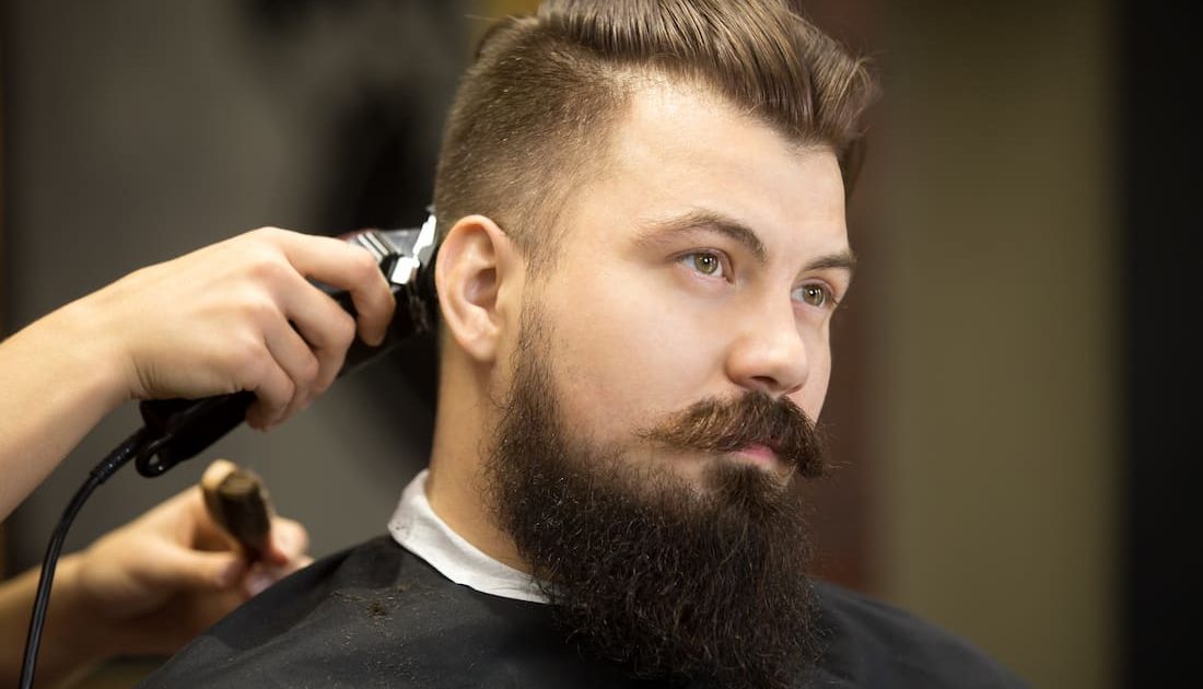 young man having hair cut at salon